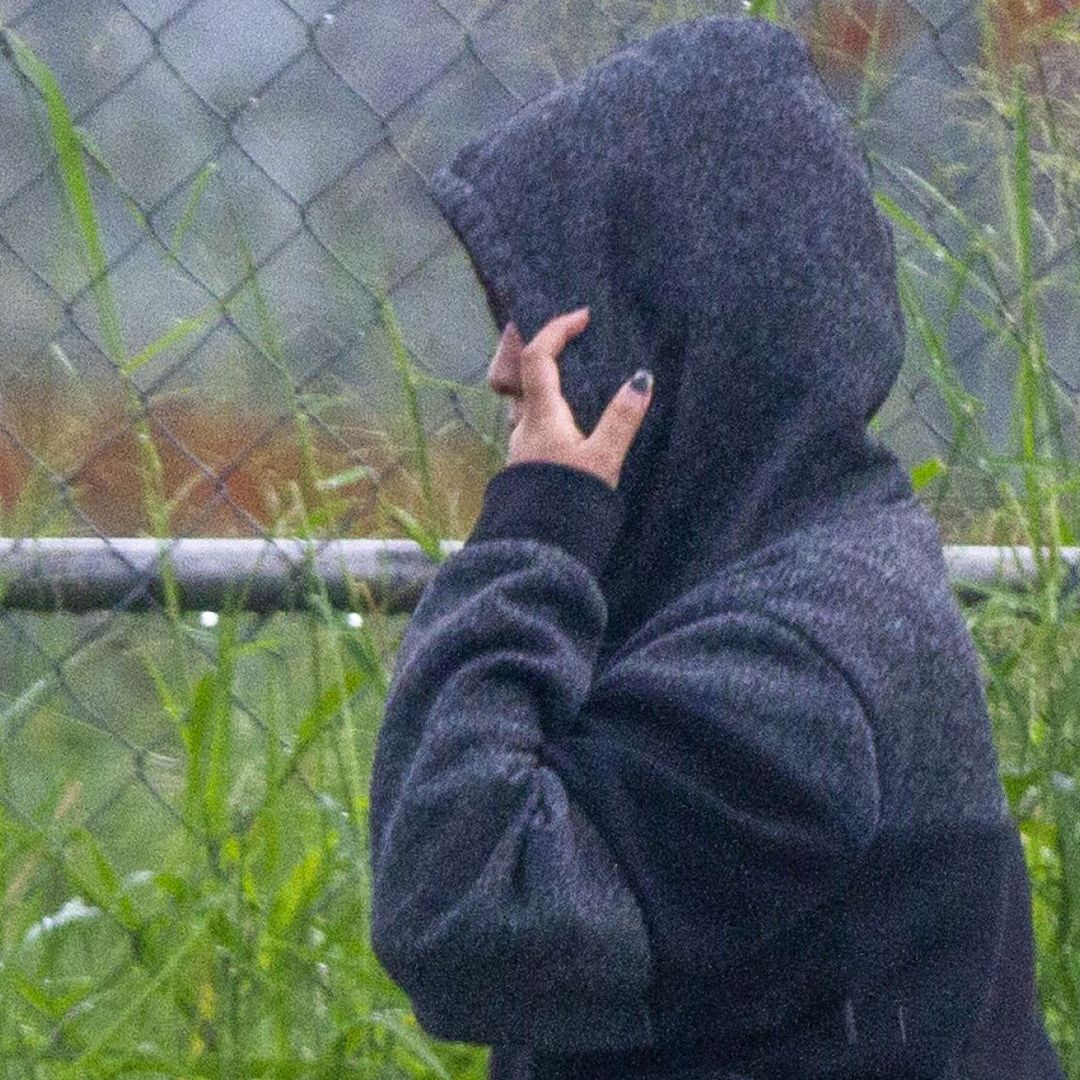 Una mujer se abriga para protegerse de la lluvia